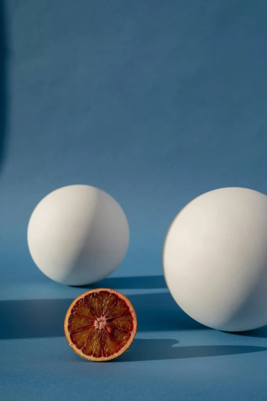 three eggs and a blood orange on a blue surface, by James Morris, photorealism, white ceramic shapes, white eclipse, ignant, by greg rutkowski