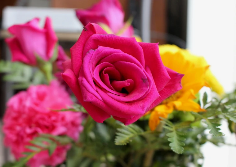 a bouquet of flowers and greens in a vase