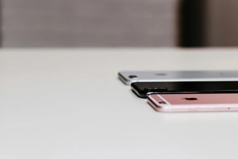 two iphones sitting side by side on a table, trending on pexels, black white pastel pink, shot on sony a 7, close up shot from the side, very thin