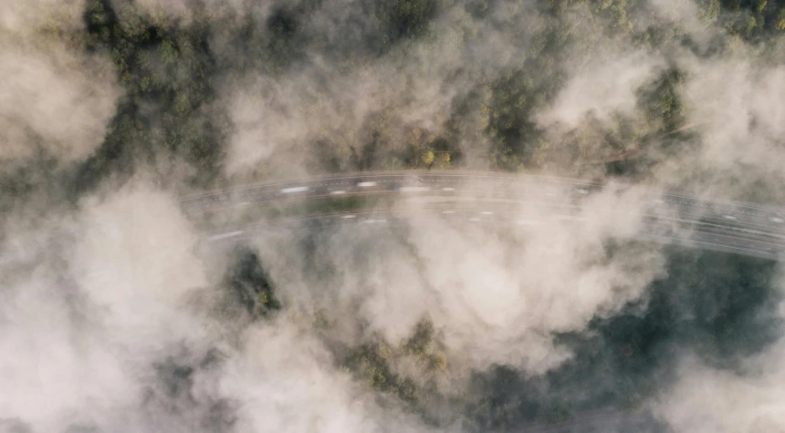 an aerial view of the road and forest