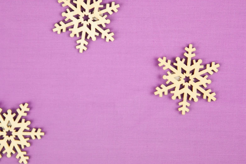 three wooden snowflakes next to each other