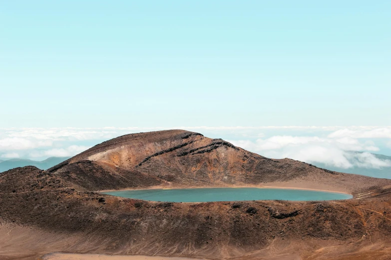 a landscape with mountains, clouds, and a body of water