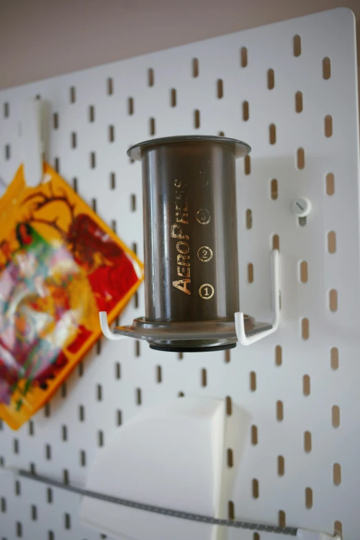 a close up of a cup on a pegboard, by Aneurin Jones, foil, product display, pepper, 4l