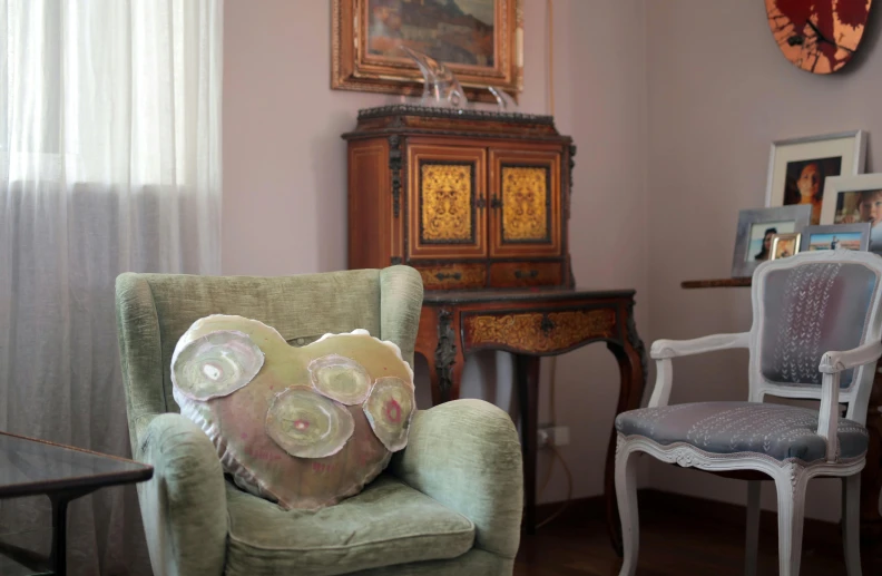 the chair has a pillow on it that is sitting in front of the dresser