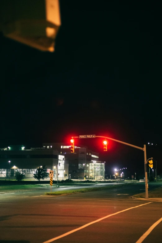 a red traffic light on a city street at night