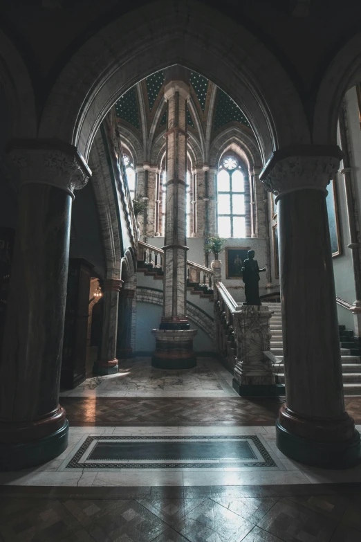 the inside of a building with columns and a staircase, inspired by Sydney Prior Hall, unsplash contest winner, gothic art, located in a castle, interior view, gothic revival, interior of a small