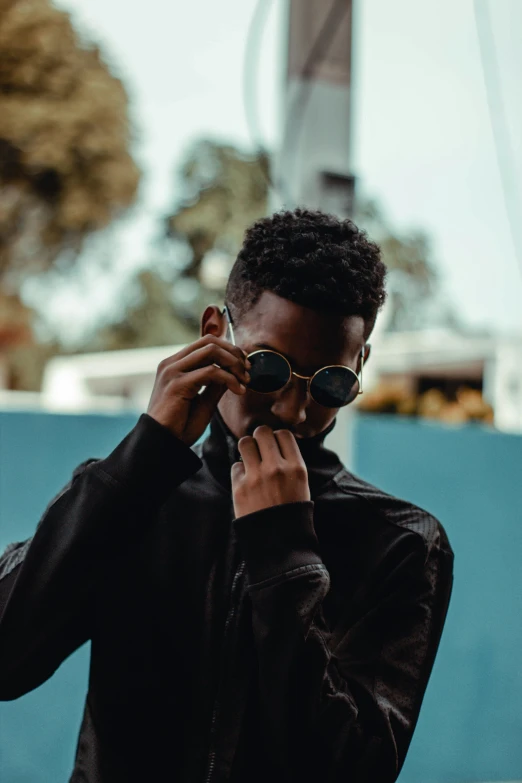 a man taking his glasses off while talking on a phone