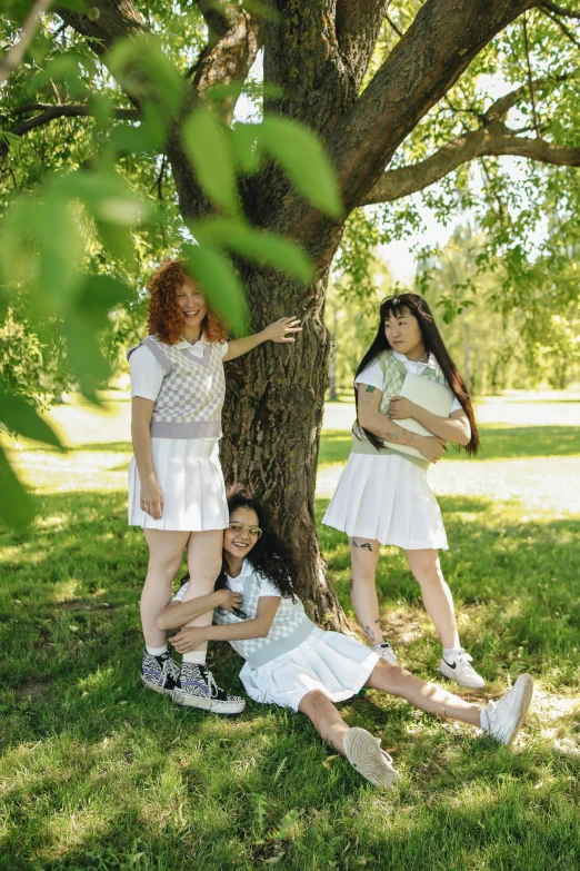 a group of young women standing next to a tree, an album cover, inspired by Konstantin Somov, pexels contest winner, tennis wear, kids playing, fashion shoot 8k, wearing white skirt