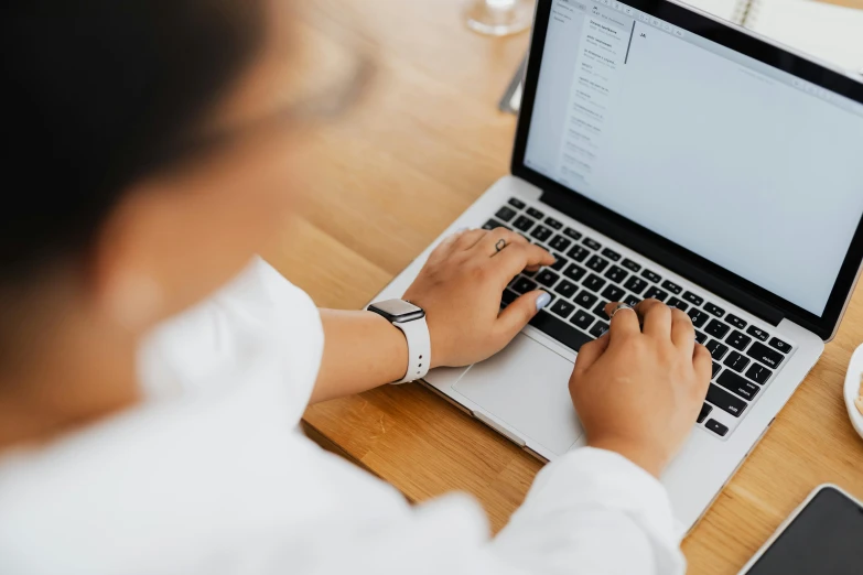 a woman sitting at a table using a laptop computer, trending on pexels, wearing a white shirt, email, background image, technical