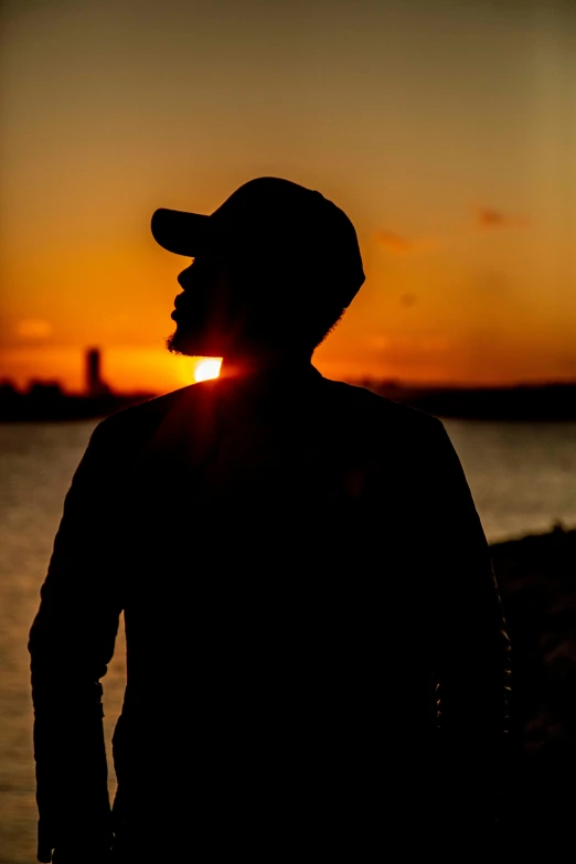 a man standing next to a body of water at sunset, profile image, silhouettes, portrait photo, photograph