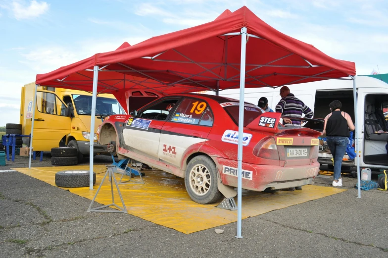 a red and white car under a red tent, tjalf sparnaay 8 k, ultra 4k, square, mechanic