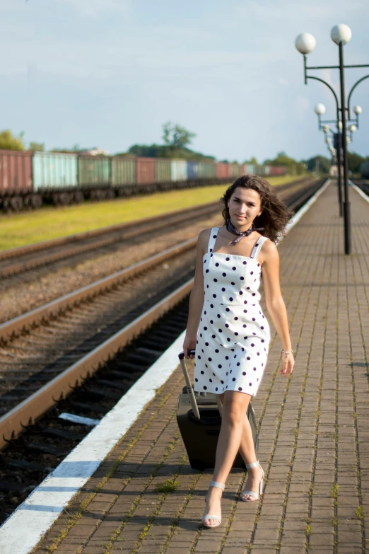 a woman walking down a train track with a suitcase, a portrait, inspired by Vasily Vereshchagin, happening, polkadots, medium, model photograph, square