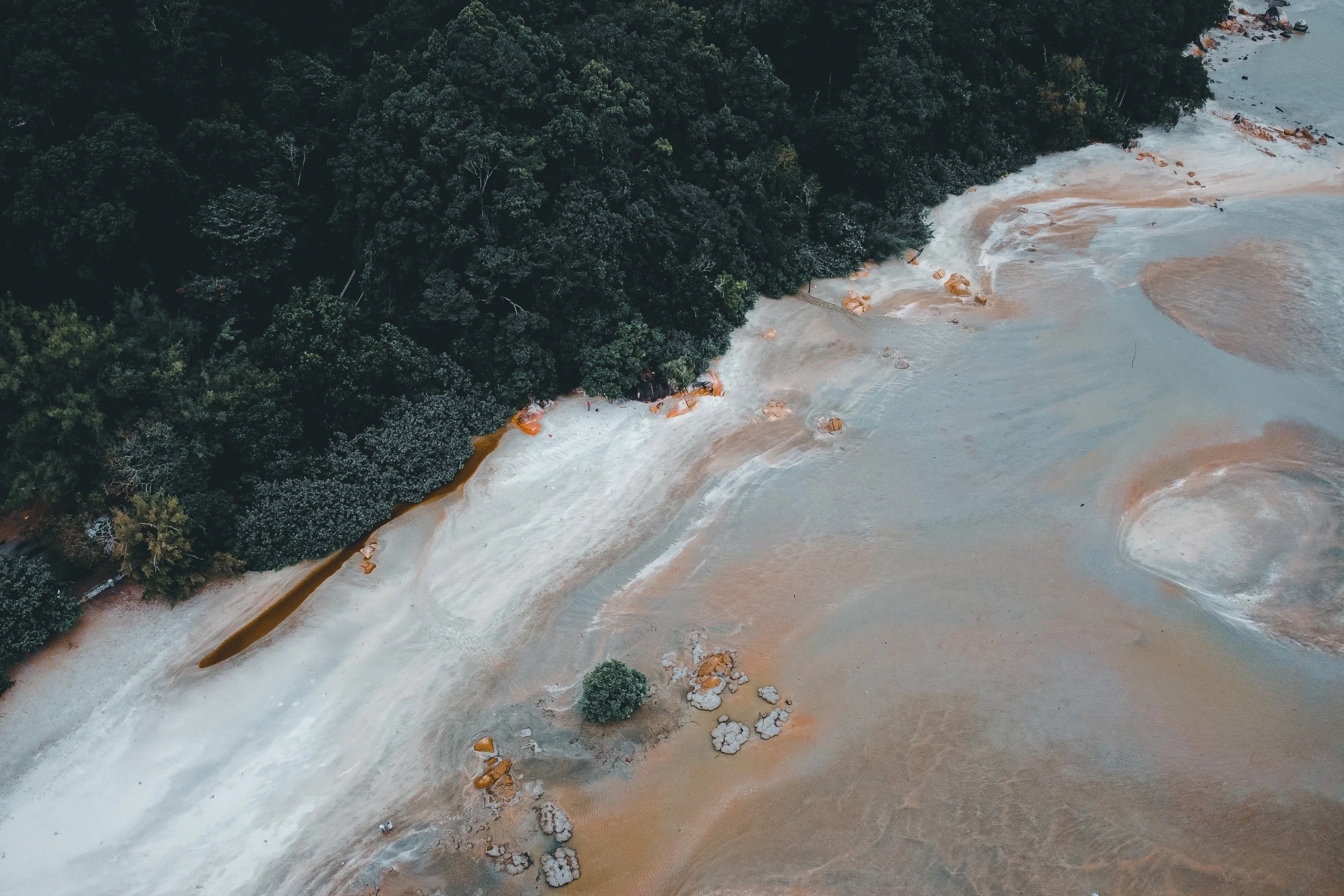 a river running through a lush green forest, a tilt shift photo, unsplash contest winner, hurufiyya, dust clouds and building debris, orange minerals, heron preston, oil spills