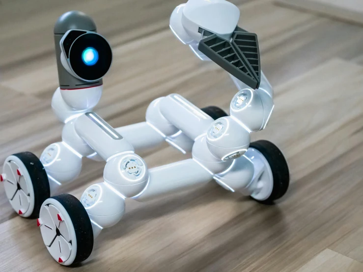 a white robot sitting on top of a wooden floor, cute future vehicles, adafruit, futuristic wheelchair, taken with sony alpha 9