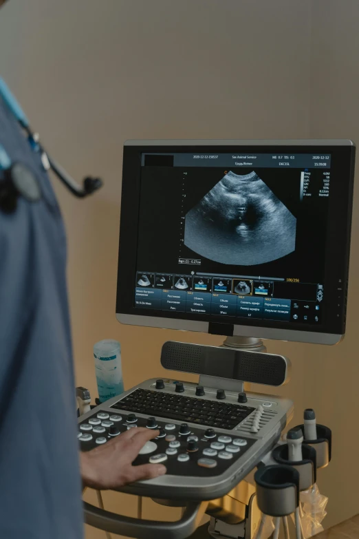 a man that is sitting in front of a computer, operating room, up-close, pregnant, neck zoomed in