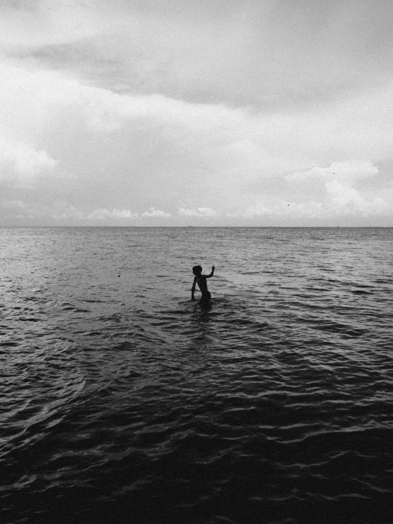 a black and white photo of a person in a body of water, unsplash, shot on expired instamatic film, open ocean, ffffound, childhood