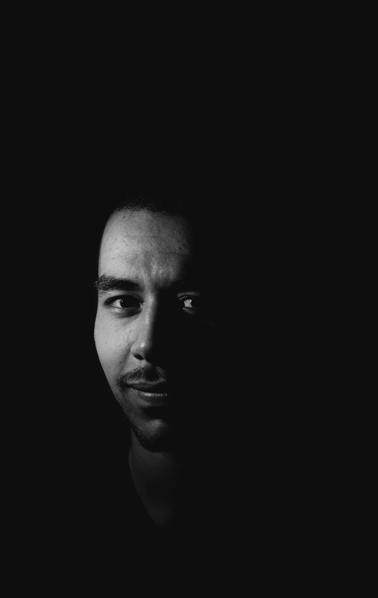 a black and white photo of a man in the dark, a black and white photo, unsplash, discord profile picture, joe taslim, arabic, programming