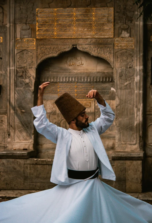 a man in a turban dancing in front of a building, inspired by Osman Hamdi Bey, pexels contest winner, arabesque, standing over a tomb stone, ( ( theatrical ) ), twirling, brown