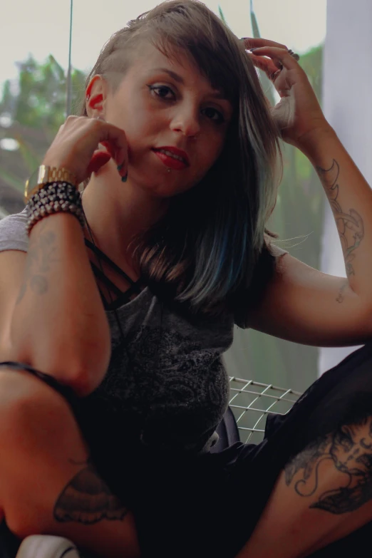a woman with tattoos sitting on a window sill, a tattoo, inspired by Elsa Bleda, low quality photo, headshot, avatar image, chloe price