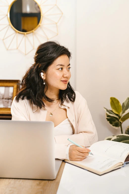 a woman sitting at a desk in front of a laptop computer, inspired by helen huang, trending on pexels, writing on a clipboard, woman with black hair, high delicate details, interview