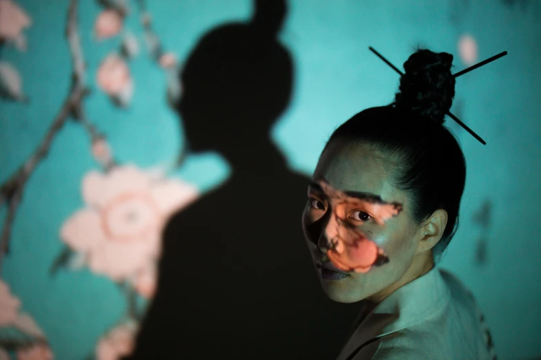 woman looking at a shadow of a face and neck on wall