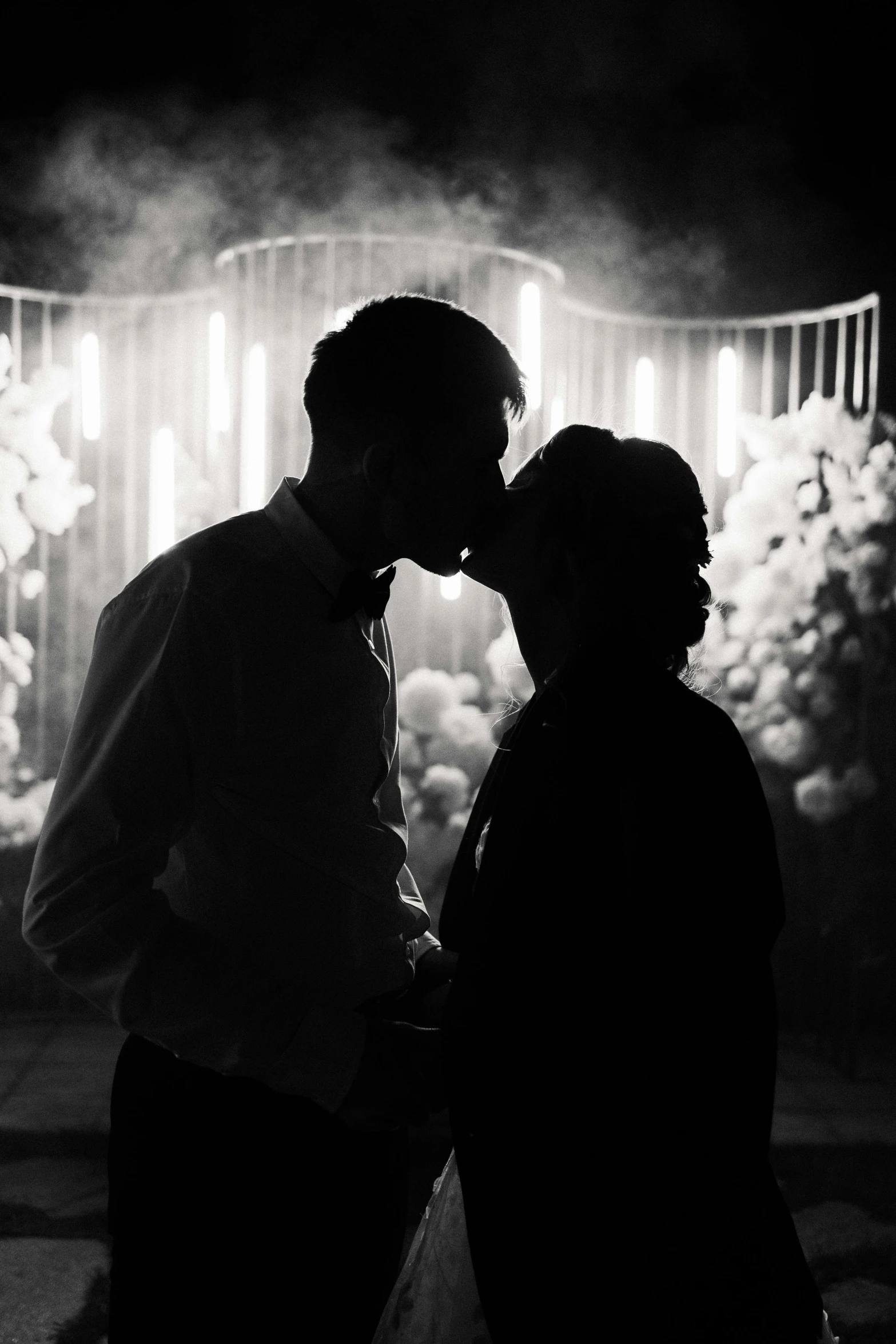 a black and white photo of a couple kissing, pexels contest winner, lights and smoke, groom, silhoutte, instagram post