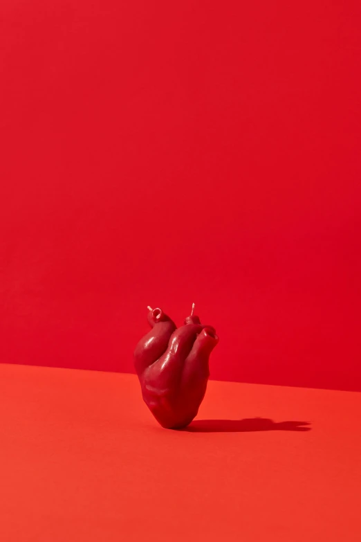 a red apple sitting on top of a red surface, holding a candle, detailed product image, forming a heart with their necks, ignant