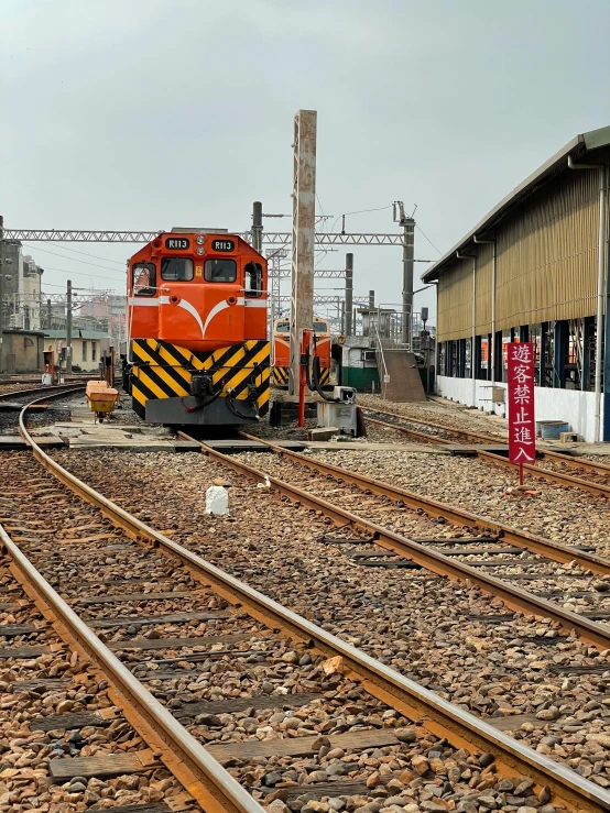 a train traveling down train tracks next to a building, from china, 🚿🗝📝, profile image