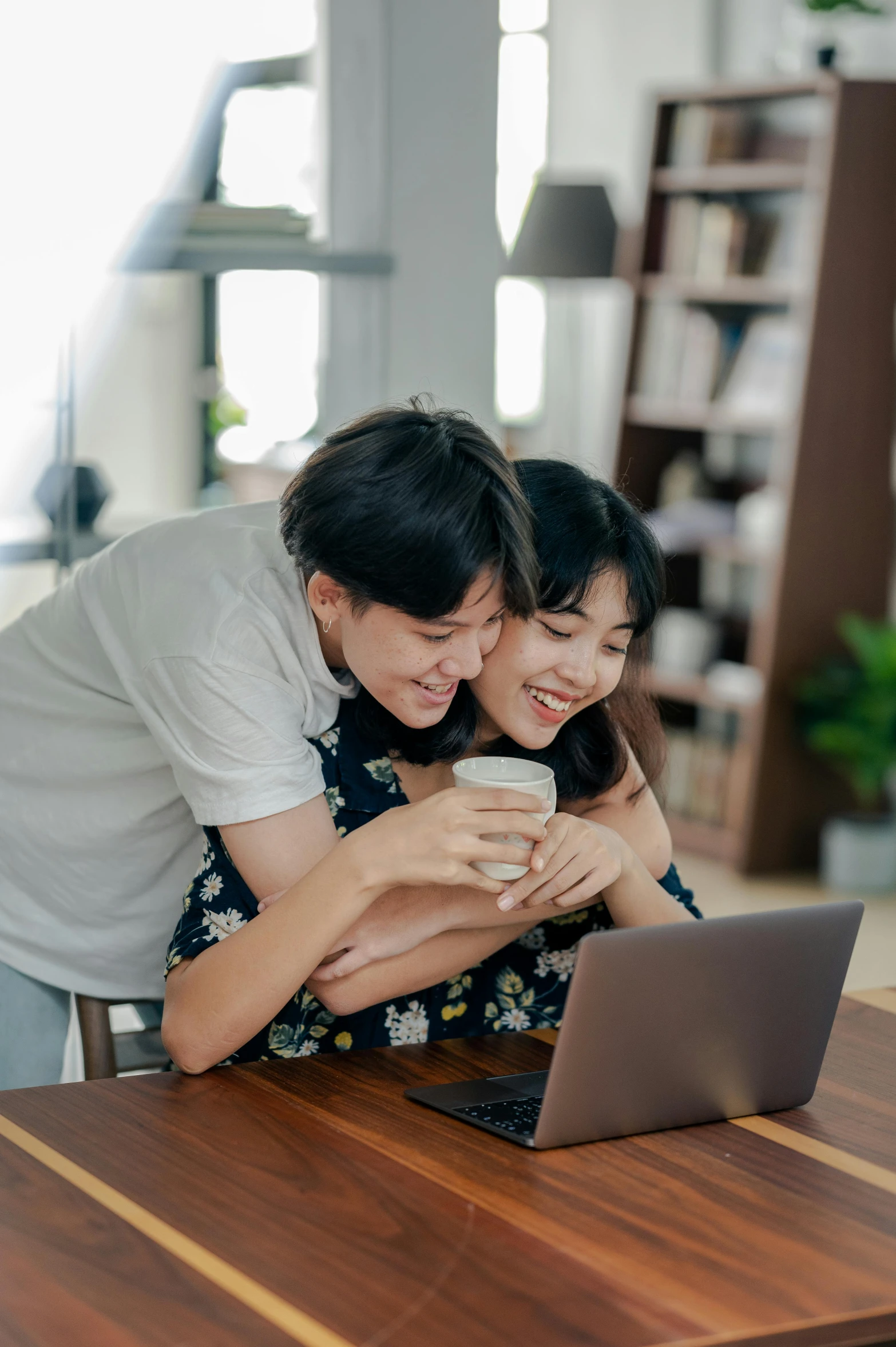 a man and woman sitting at a table looking at a laptop, pexels contest winner, happening, japanese collection product, hugging, jakarta, on a coffee table