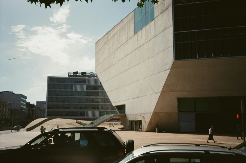 some cars a building and a man walking down the street