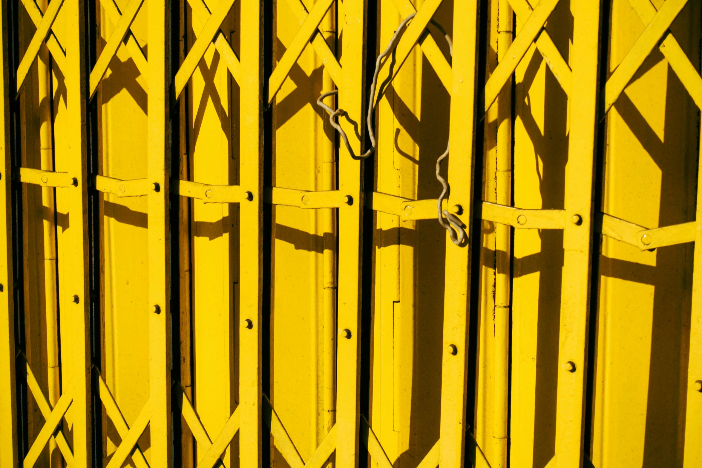 a yellow gate with a chain attached to it, pexels contest winner, contrasted lighting and shadows, shot with sony alpha, patterned, test