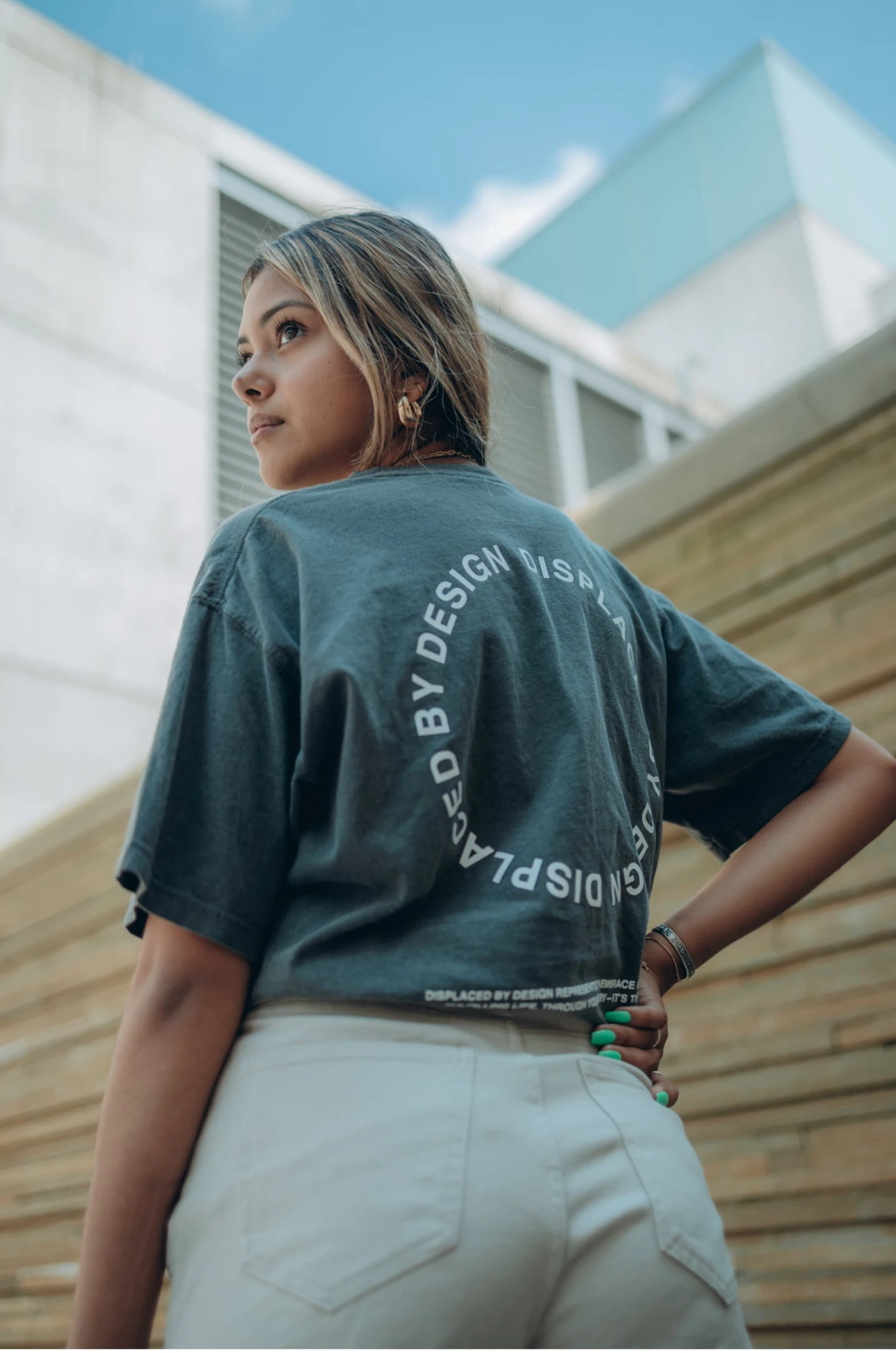 a woman standing in front of a building, wearing pants and a t-shirt, circle design, behance lemanoosh, são paulo