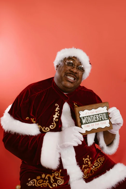 a man in a santa suit holding a sign with the word wonderful written on it