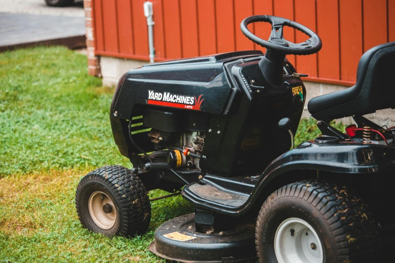 a lawn mower sitting on top of a lush green field, a portrait, pexels contest winner, auto-destructive art, black steel with red trim, gasoline engine, in a suburban backyard, 1 6 x 1 6