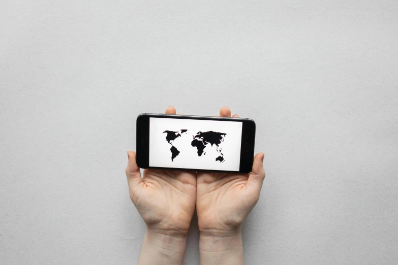 a person holding a cell phone with a world map on it, by Daniel Lieske, visual art, 9 9 designs, real photo, trending photo, minimalistic