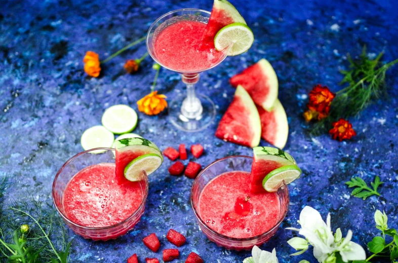 two glasses filled with watermelon and lime garnish, by Julia Pishtar, squashed berries, background image, fan favorite, cosmopolitan