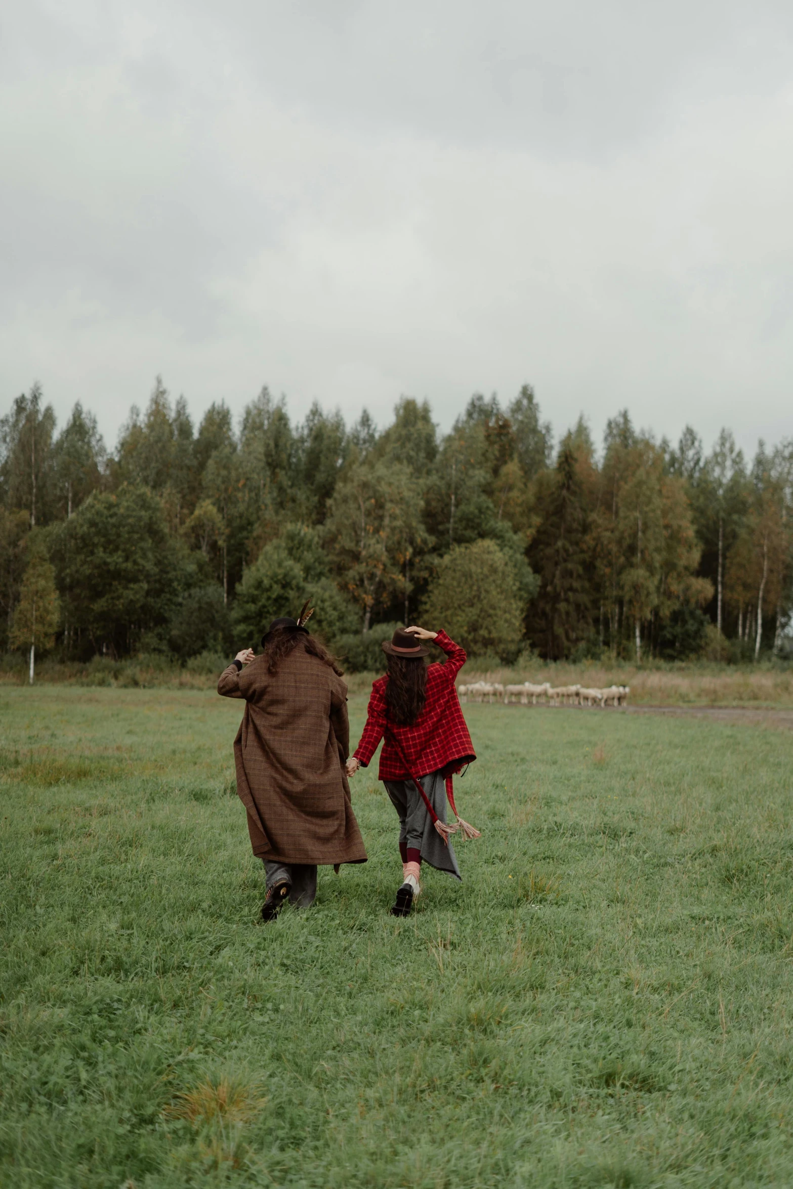 a couple of people standing on top of a lush green field, inspired by Andrei Rublev, unsplash contest winner, wearing red fur cloak, leaving for battle, [ cinematic, young girls