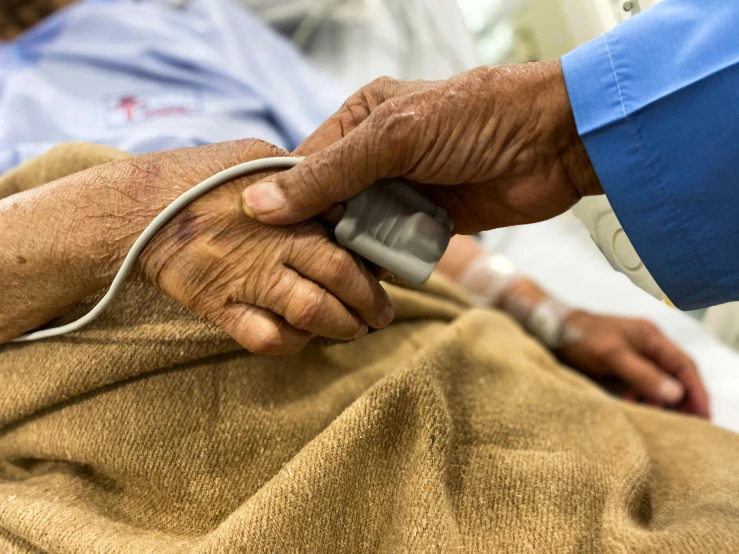 a close up of a person laying in a hospital bed, corrected hand, older male, with electric arc device, connectivity