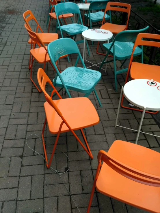 a row of orange and blue chairs and tables, by Doug Ohlson, temporary art, south jakarta, phone photo, teal orange, patio