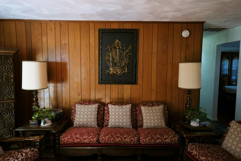 the inside of a house with wood paneling and red couch