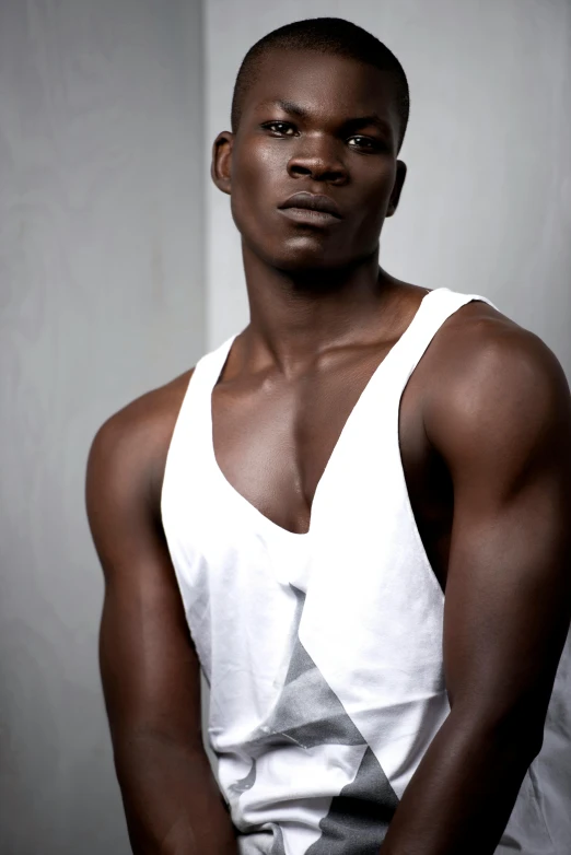 a man in a white tank top posing for a picture, inspired by Terrell James, pexels contest winner, adut akech, gray skin, upscale photo, large)}]