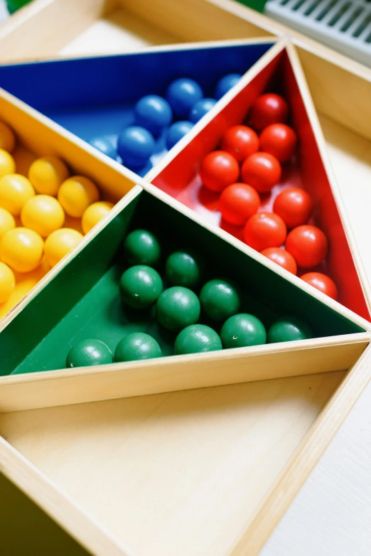 a wooden tray filled with different colored balls, inspired by Giacomo Balla, bauhaus, mathematics, archive photo, boys, triangle