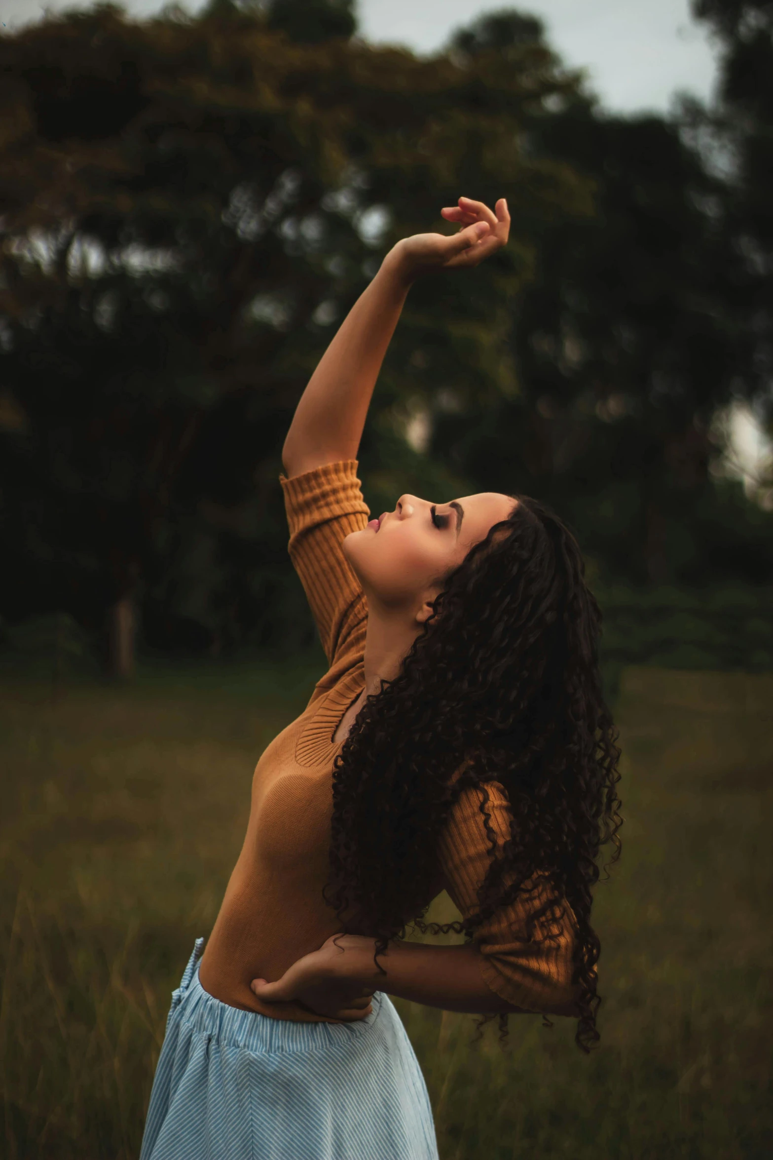 a woman reaching for an object in a field