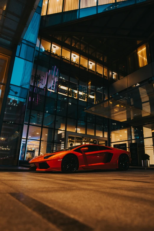 a very nice looking red car near some big buildings