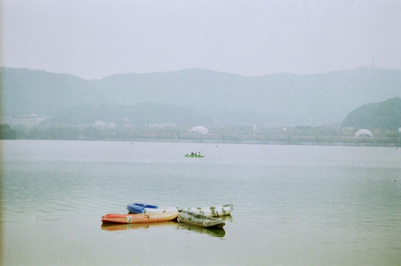 a group of boats floating on top of a lake, inspired by Zhang Kechun, unsplash, mingei, color film expired film, a park, spring day