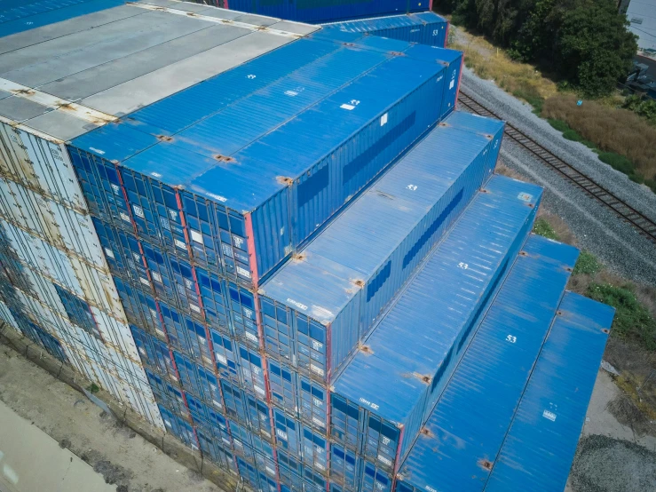 a bunch of containers stacked on top of each other, a portrait, unsplash, drone footage, te pae, chemrail, blue colour scheme