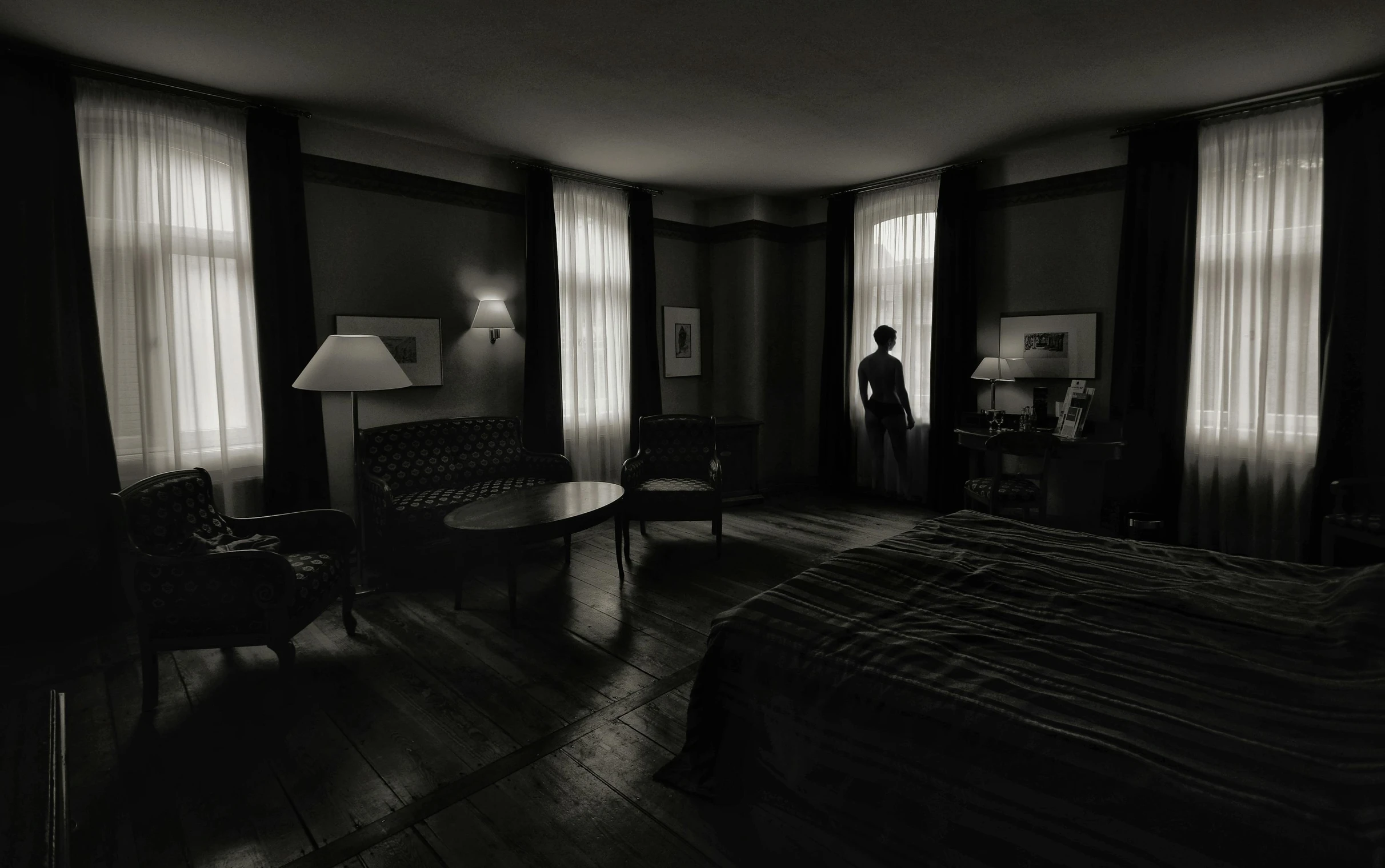 a dark bedroom has a desk and several curtains