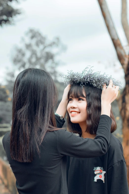 a woman putting a crown on another woman's head, by Tan Ting-pho, pexels contest winner, aestheticism, fluffy bangs, with black vines, fall season, shoulder-length black hair