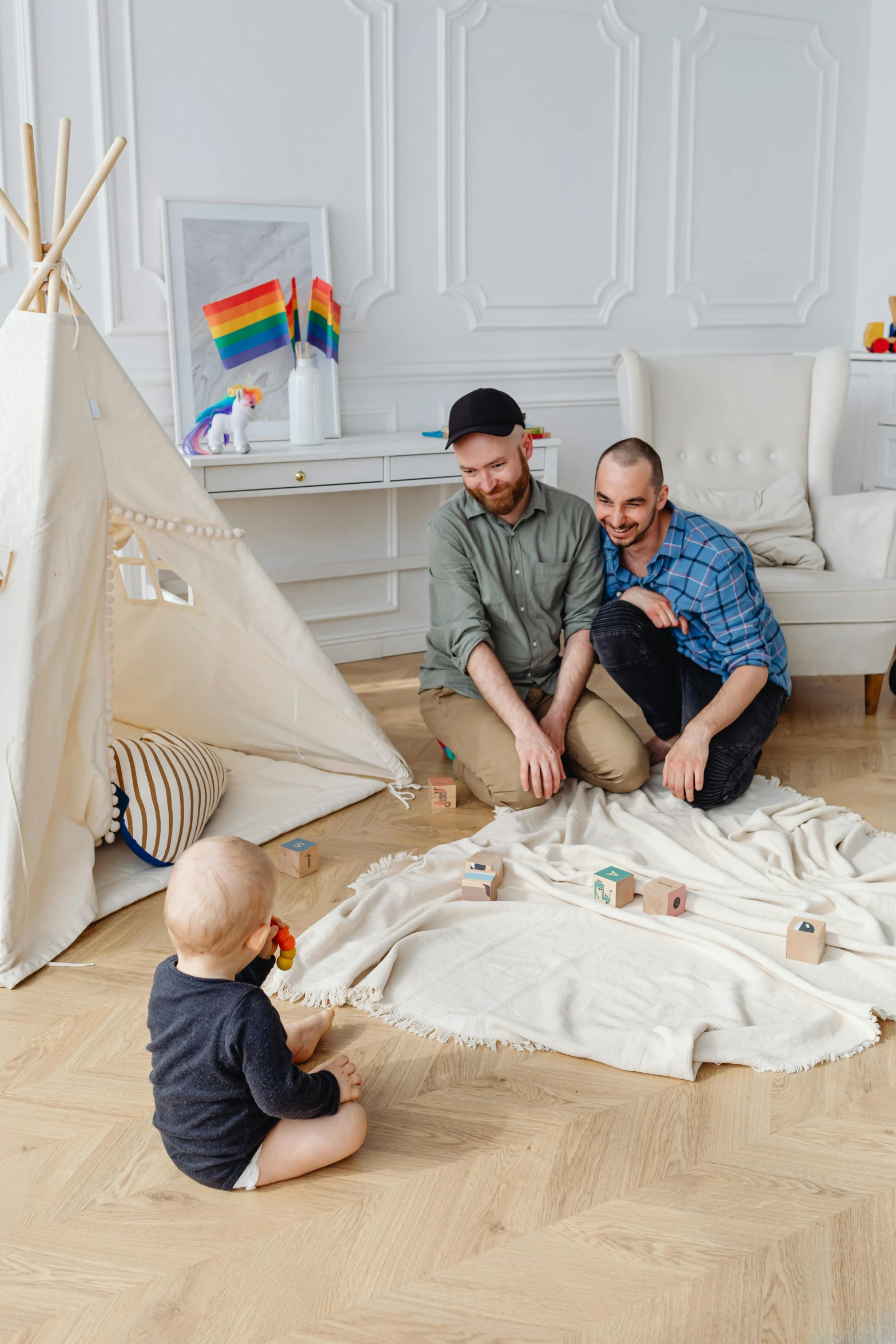 a group of people sitting on top of a wooden floor, inspired by The Family Circus, pexels contest winner, teepee, two buddies sitting in a room, father with child, lgbt