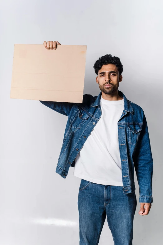 a man is holding up a white sign